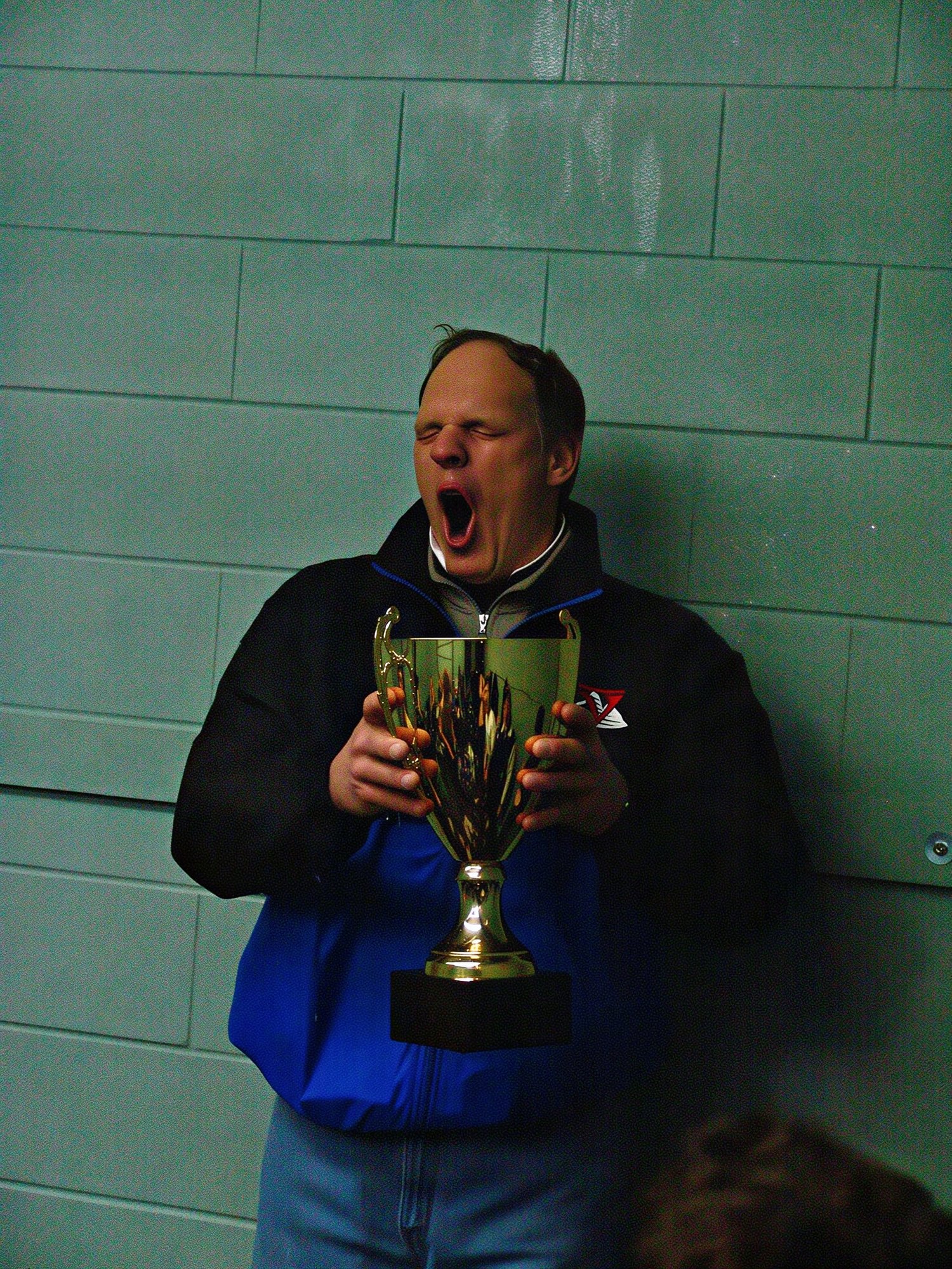 Coach Scott Hovey with the cup - and getting squirted by a water bottle.