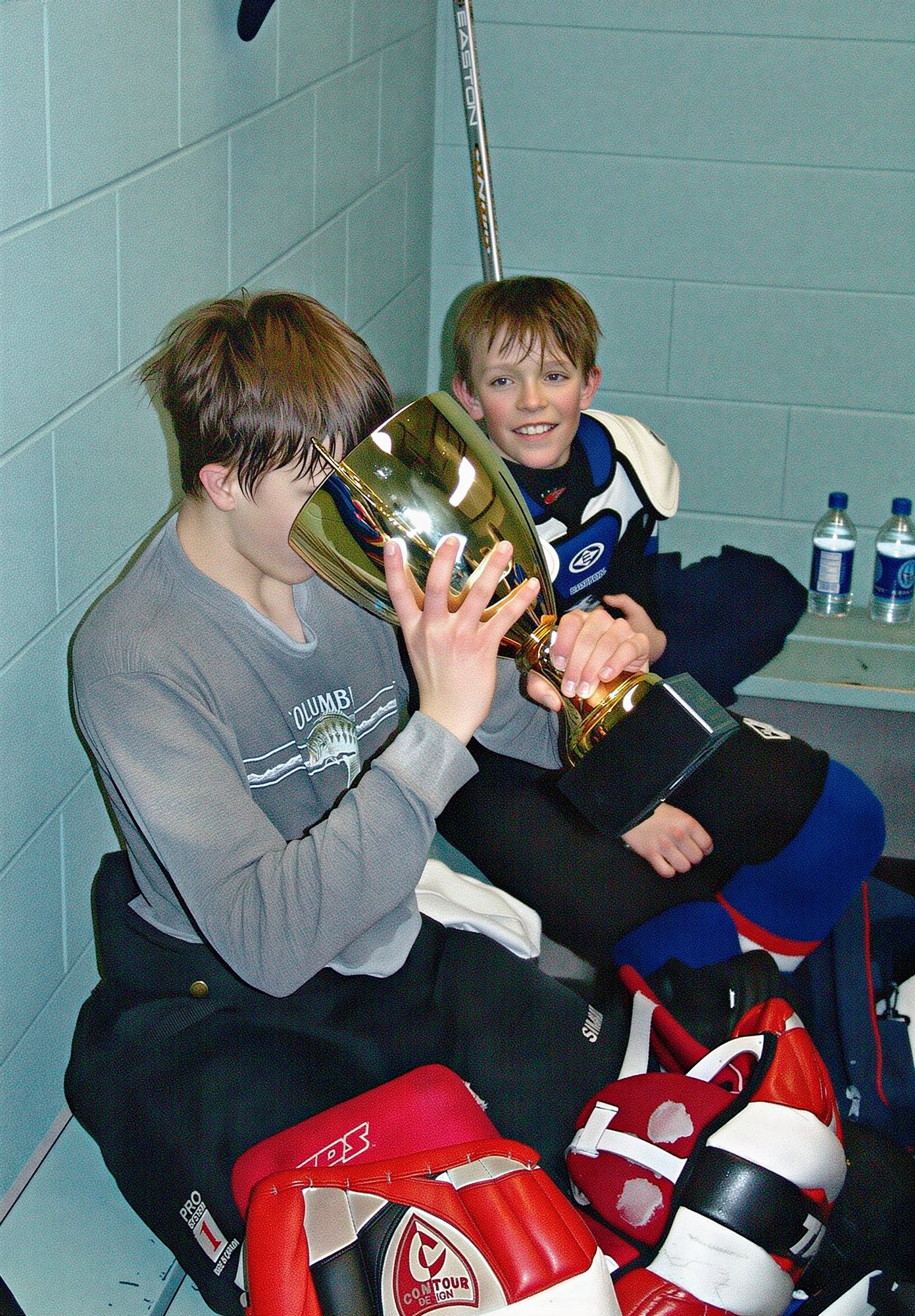 The winning goalie, Foster Fox, enjoying a soft drink from the cup.  Blake Armstrong in background
